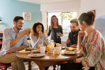 Obraz premium bunch of multi-ethnic friends gathered around a table for breakfast