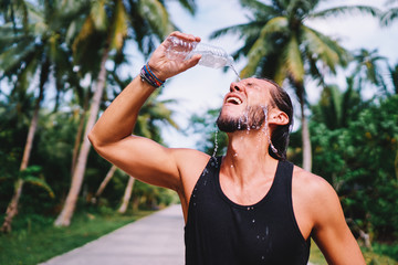 Sports lifestyle. Young man with bottle of water outdoors.