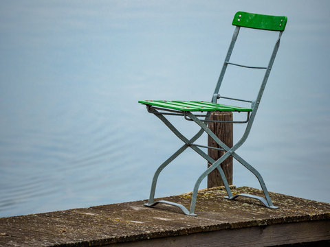 grüner Stuhl auf Bootsteg 