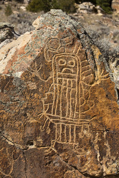 Petroglyph Rock Carving Of Human Figure On Boulder In Wyoming Mountains