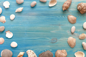 Summer vacation background with copy space. Many seashells and pebbles on blue background mock up.