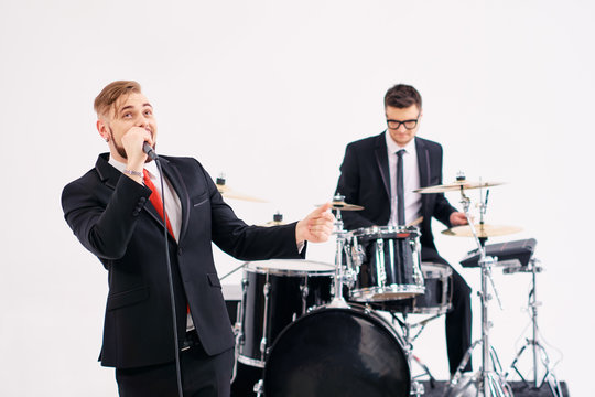 Handsome young men in suits playing rock and singing song.