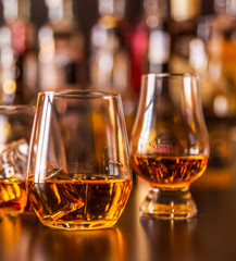 Scottish whisky in a glass with ice cubes, golden color whiskey
