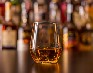 Scottish whisky in a glass with ice cubes, golden color whiskey