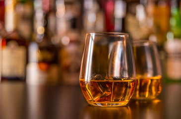 Scottish whisky in a glass with ice cubes, golden color whiskey