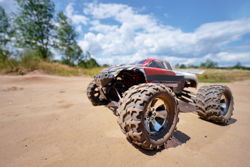 Radio controlled car model in race on the sandy road.