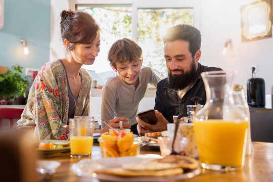  Family Breakfast, Dad Shares A Video On A Phone To His Son