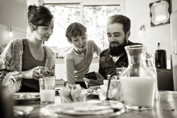  Family breakfast, Dad shares a video on a phone to his son