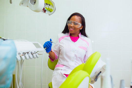 young black girl doctor dentist treats white girl's teeth. - Powered by Adobe