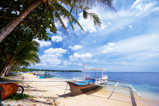 Beautiful landscape with tropical white sand beach with fishing boats. Siargao Island, Philippines.