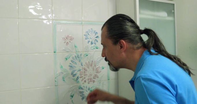Obsessive man cleaning bathroom