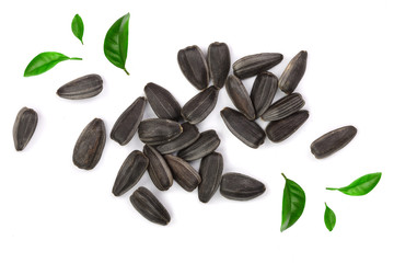 Sunflower seeds decorated with green leaves isolated on white background. Top view