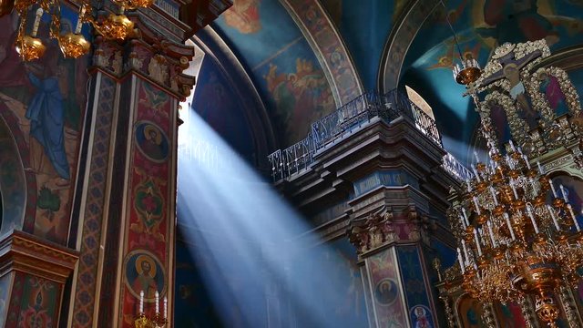A prayer is held in the Orthodox church. The rays of the sun shine through the window into the room. Ukraine, Vinnitsa, June 2018.