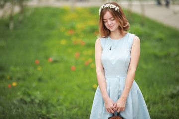 Girl in blue dress in green park