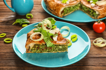 Piece of tasty pie with spinach on plate