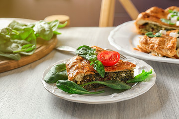 Piece of tasty pie with spinach on table