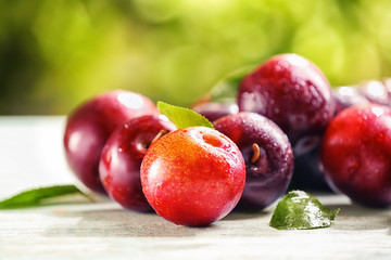 Ripe juicy plums on table