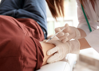 Doctor vaccinating male patient in clinic