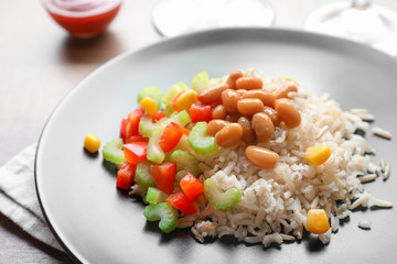 Brown rice with vegetables on plate, closeup