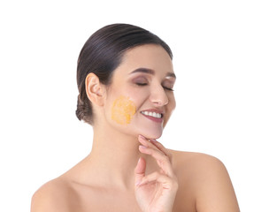 Young woman with natural scrub on her face against white background