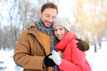 Obraz premium Young couple in snowy park on winter vacation