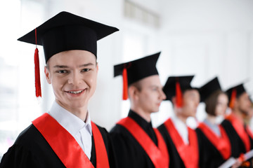 Student in bachelor robe indoors. Graduation day