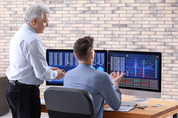 Male brokers working in office. Finance trading concept