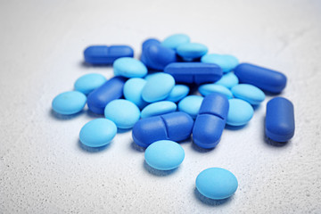 Blue pills on white background, closeup