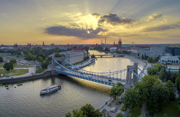 Widok z lotu ptaka na mosty, statek na rzece oraz zachodzące słońce - Wrocław, Polska © Piotr Mitelski