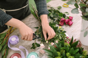 Obraz na płótnie Canvas Male florist making beautiful bouquet in flower shop, closeup