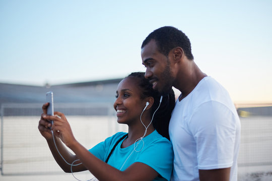 Young african couple taking a self-portrait late at evening outdoors