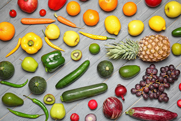 Rainbow collection of ripe fruits and vegetables on grey background, top view