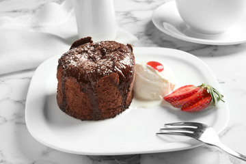 Plate of delicious fresh fondant with hot chocolate, ice cream and strawberry on table. Lava cake...