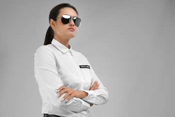 Female security guard in uniform on color background