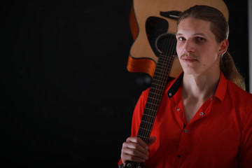 Obraz premium Young man with long hair with a guitar