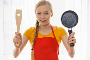 Woman holding cooking pan and spatula