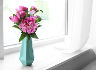 Vase with beautiful peony flowers on windowsill indoors