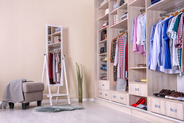 Large wardrobe with different clothes and shoes