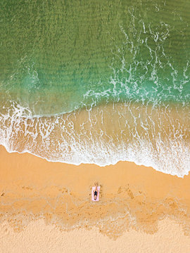 Fototapeta Woman sunbathing alone on an empty beach