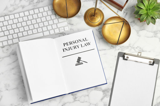 Flat Lay Composition With Book, Scales Of Justice And Computer Keyboard On Marble Background. Personal Injury Law Concept