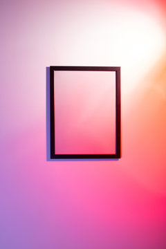 Empty frame hanging on a colorful wall