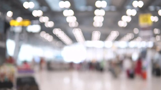 Blurred footage of passengers walking in the International airport terminal. 4K video with defocused effect.