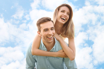 Cute young couple in love posing on light background