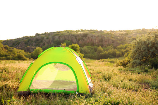 Small camping tent in wilderness on sunny day