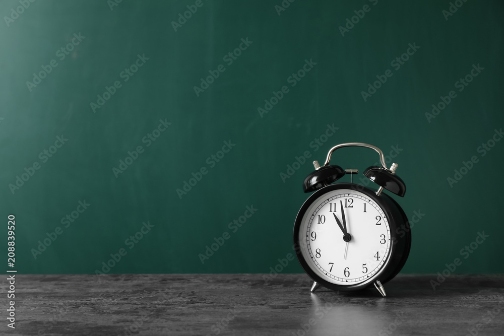 Poster alarm clock on table against color background. time concept