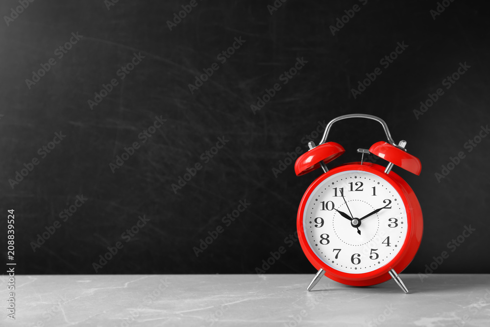 Aufkleber alarm clock on table against color background. time concept