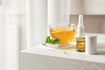 Remedies for cold and cup of hot tea on table