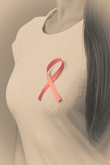 Pink ribbon on woman chest to support breast cancer cause