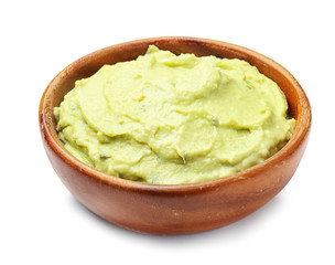 Bowl with guacamole made of ripe avocados on white background