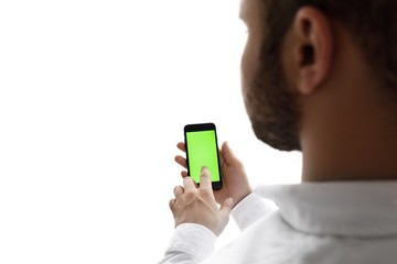 Man using mobile phone while standing near window. Chroma key